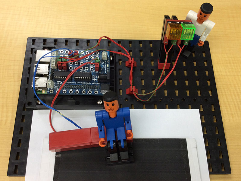 赤外線センサーの上に座っている青フィッシャー君と陰でそれを見つめている白フィッシャー君